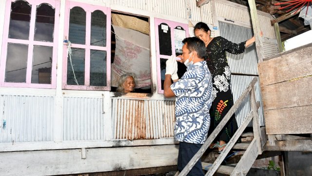 Wakil Ketua DPRD Sulsel , Syaharuddin Alrif Menyapa Ibu Usia Lanjut yang Melihat Dirinya Dari Salam Rumah Melalui Jendela 
