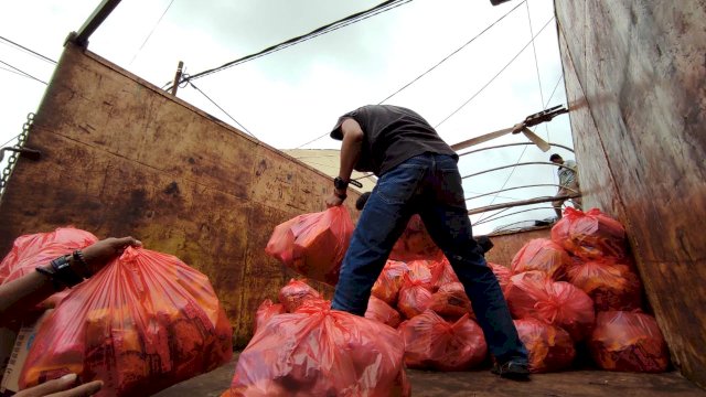 Saat relawan JPS menaikkan ratusan paket logistik ke mobil truk untuk disalurkan ke Sulbar, Jumat (22/1). Dok: Antara