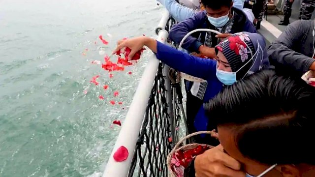 Kerabat Indonesia dari korban penerbangan Sriwijaya yang jatuh meletakkan bunga sebagai penghormatan. Laporan awal kecelakaan itu diharapkan pada awal Februari 2021, || Dok: Bagus Indahono/EPA.