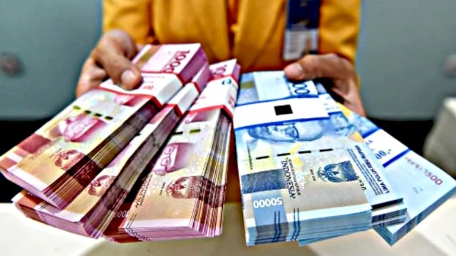Seseorang yang memegang uang puluhan juta. (Antara)
