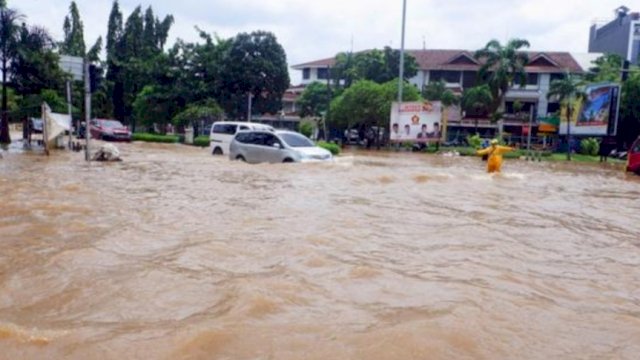 Kendaraan saat melintasi jalan yang tergenang banjir di kawasan Puri Indah, Kembangan, Jakarta Barat, Sabtu (20/2/2021). | AKURAT.CO/Sopian