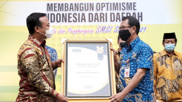 Plt Gubernur Sulsel memberikan penghargaan kepada perwakilan Bupati Gowa, Jumat (26/3). [trotoar.id].