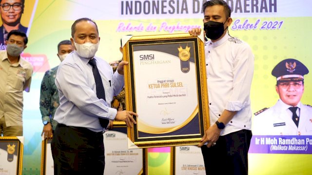 Ketua PHRI saat menerima penghargaan yang diserahkan oleh inisiator SMSI.