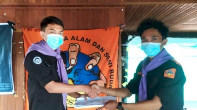Penyerahan konstitusi oleh Koordinator Steering Committee Musker ke-20 Novan Arisandi ke Ketua Umum MPAS Maestro FBS UNM Periode 2021-2022 Akbar Maulana. (Dok. MPAS Maestro)