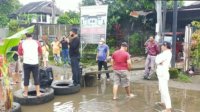 FOTO: Diduga Kesal karena Selalu Tergenang Air, Warga Kota Makassar Blokir Lalin dan Tanam Pisang di Tengah Jalan