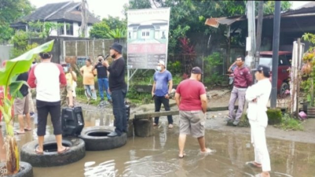 FOTO: Diduga Kesal karena Selalu Tergenang Air, Warga Kota Makassar Blokir Lalin dan Tanam Pisang di Tengah Jalan