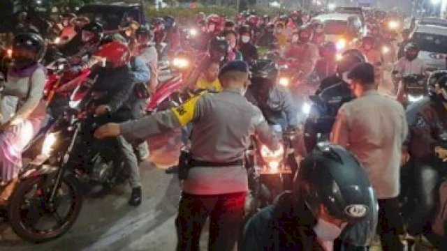 Tampak satu orang anggota polisi tengah menahan laju pengendara yang sedang melakukan mudik lebaran, kemarin.