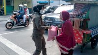 Satuan Polisi Pamong Praja Pemkot Makassar Bagikan Paket Bahan Pokok Kepada Pedagang Kaki Lima
