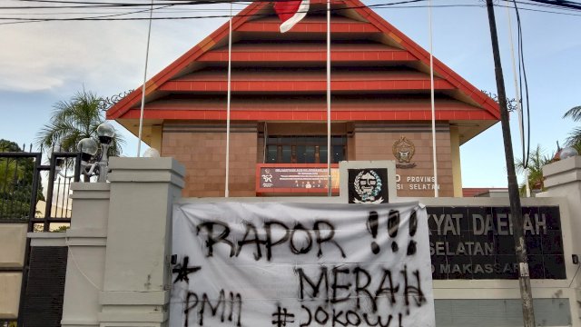 Nampak sebuah spanduk yang telah ditulisi oleh mahasiswa sehingga menutupi papan nama DPRD Sulsel, Kamis (28/10). | Alam/trotoar.