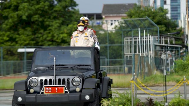 Plt Gubernur Sulsel, Andi Sudirman Sulaiman, berdiri di atas sebuah mobil. 