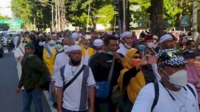 Peserta Reuni 212 tampak berjalan kaki di trotoar jalan raya. (Detikcom)