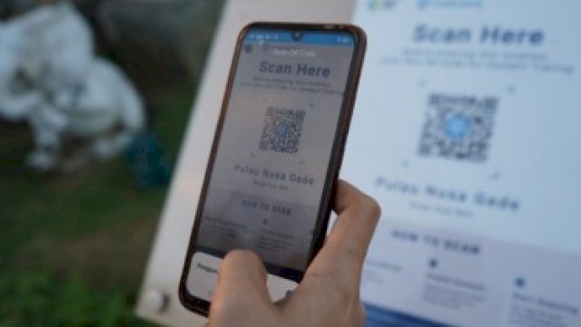 Seseorang sedang menggenggam hp, memperlihatkan scan Peduli Lindungi. (Ist)