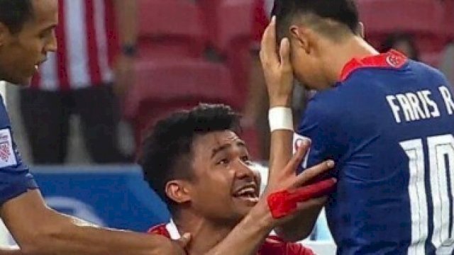 Pemain bintang Timnas Indonesia, Asnawi M, memegang salah seorang pemain Singapura usai gagal cetak gol penalti. (Ist)