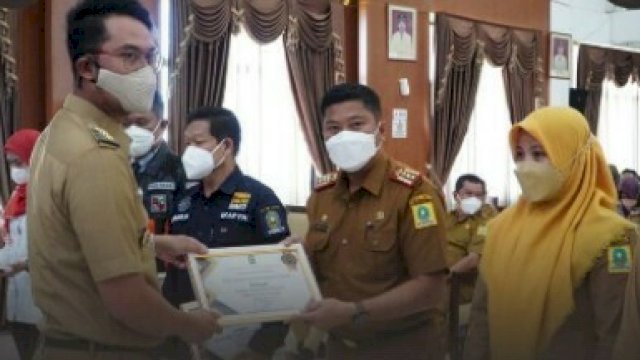Penyerahan penghargaan dari Bupati Andi Seto kepada Kadis Bappeda Irwan Suaib.