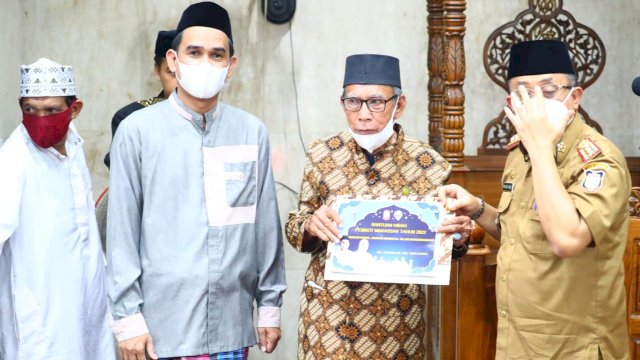 Rudianto Lallo menyerahkan bantuan dana ke pengurus masjid.