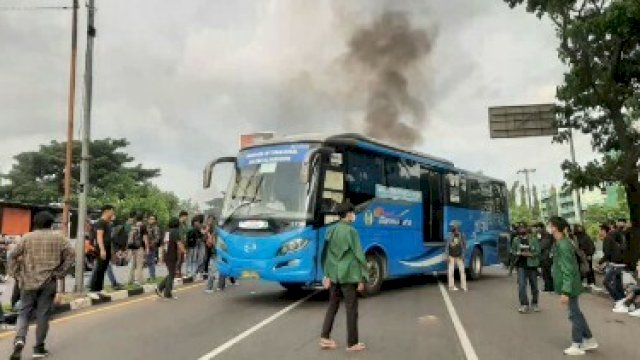 Terlihat mahasiswa menahan mobil bus di Jalan Urip Sumoharjo, Makassar, saat menggelar aksi demonstrasi. Jumat (8/4).