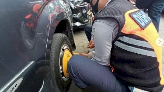 Petugas Dishub menggembok kendaraan yang parkir di sembarang tempat.