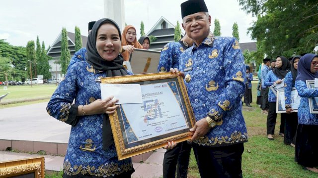 Bupati Luwu Basmin Mattayang Memberikan Piagam penghargaan Kepada Salah Satu ASN di Puncak peringatan Hari Kopri 