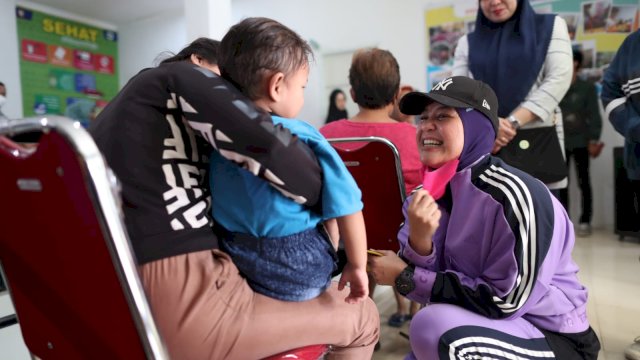 Wakil Walikota Makassar, Fatmawati Rusdi Menyapa Anak  yang di Pangku Ornag Tuanya di Salah Satu Puskesmas d