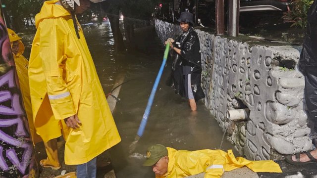 Petugas Kebersihan Melakukan Pembersihan Saluran Air, di jalan Sebagian Wilayah KOta Makassar Tergenang Air akibat hujan deras 