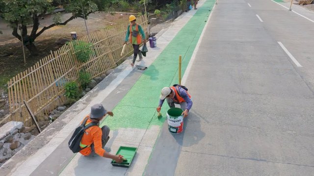 Nampak pekerja  melakukan pengecetan Marka jalan